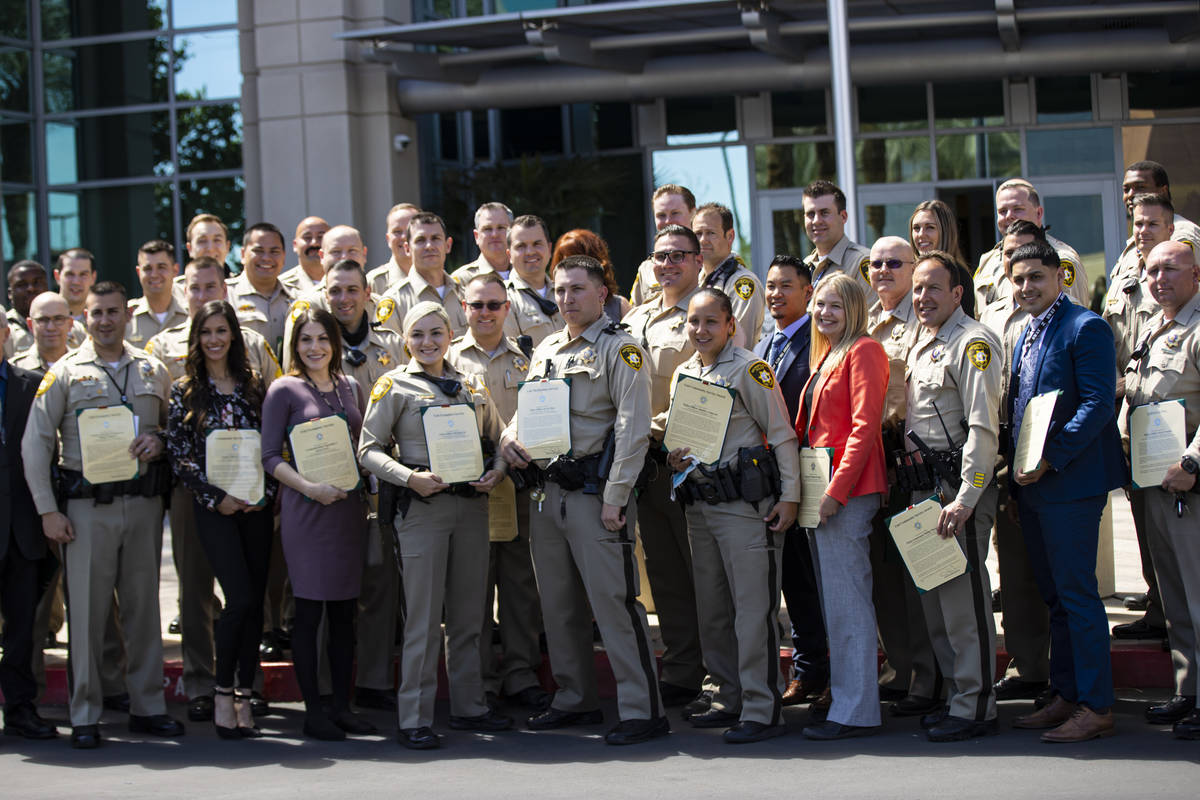 Agentes y empleados del Departamento de Policía Metropolitana posan para una foto grupal con s ...
