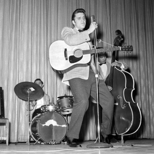 Elvis Presley canta, junto con D.J. Fontana a la batería y Bill Black al bajo, en Venus Room d ...