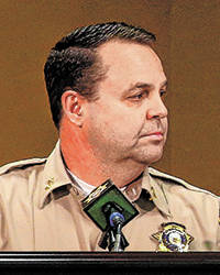 Assistant Sheriff Chris Jones watches video of Jorge Gomez, a heavily armed suspect who was kil ...