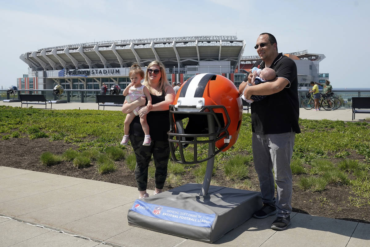 Fans posan para una foto con un gran casco de los Cleveland Browns el martes, 27 de abril de 20 ...