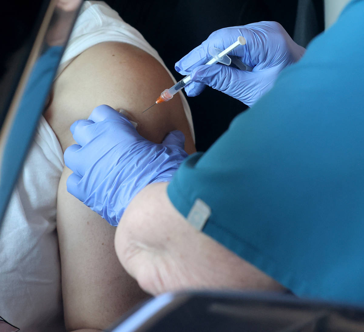 Teresa Woods da una inyección en una clínica drive-thru de vacunas contra COVID-19 en Bronze ...