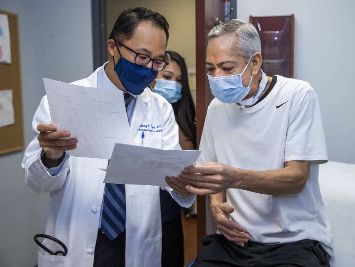 El doctor Anthony Nguyen, a la izquierda, consulta los resultados de las pruebas con el pacient ...