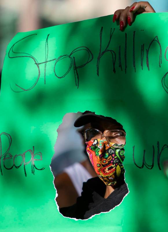 Jameelah Lewis sostiene un cartel en el que se lee "dejen de matar a la gente que se parece a m ...