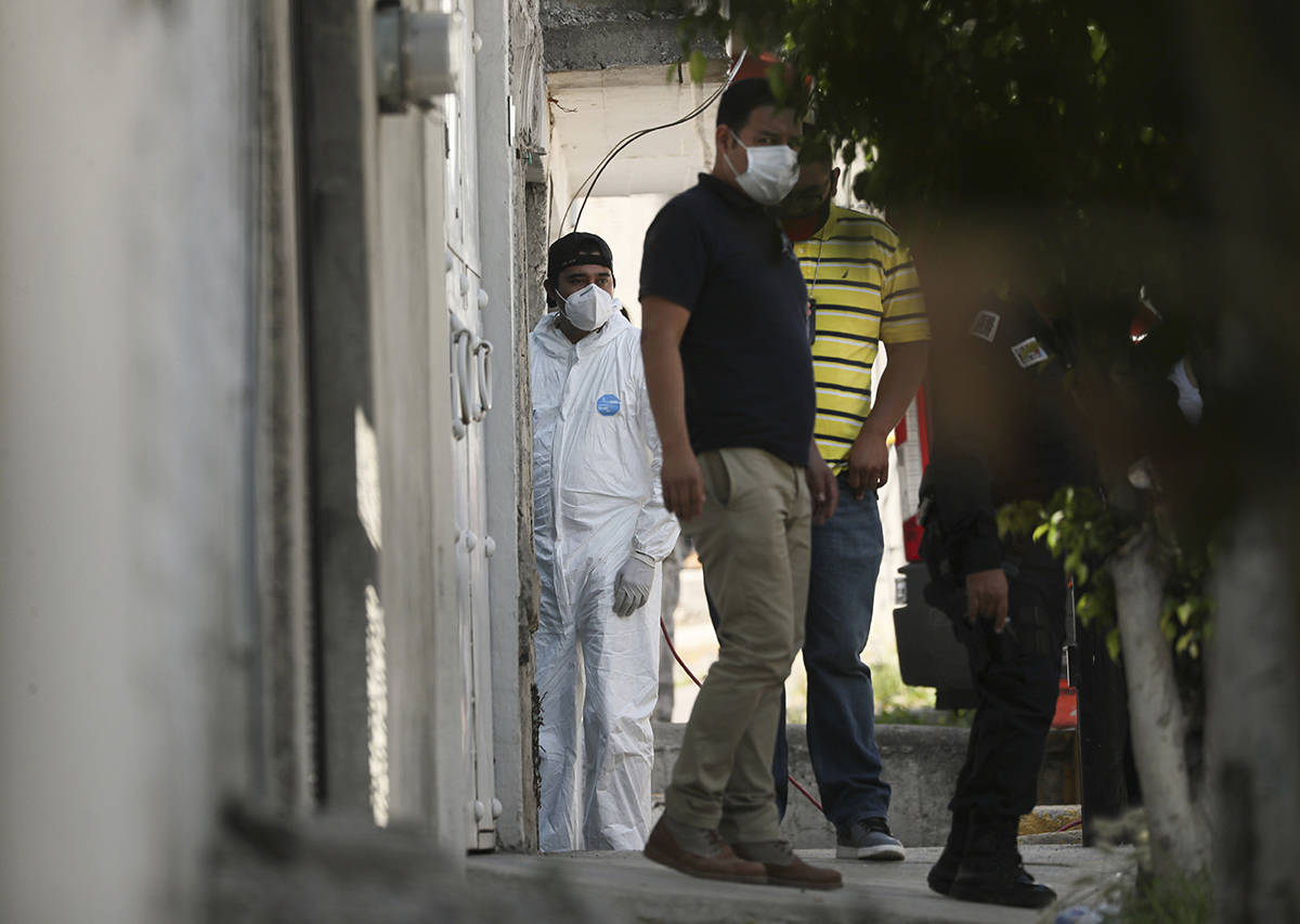 Un investigador forense se ubica en la entrada de una casa donde la policía encontró huesos d ...