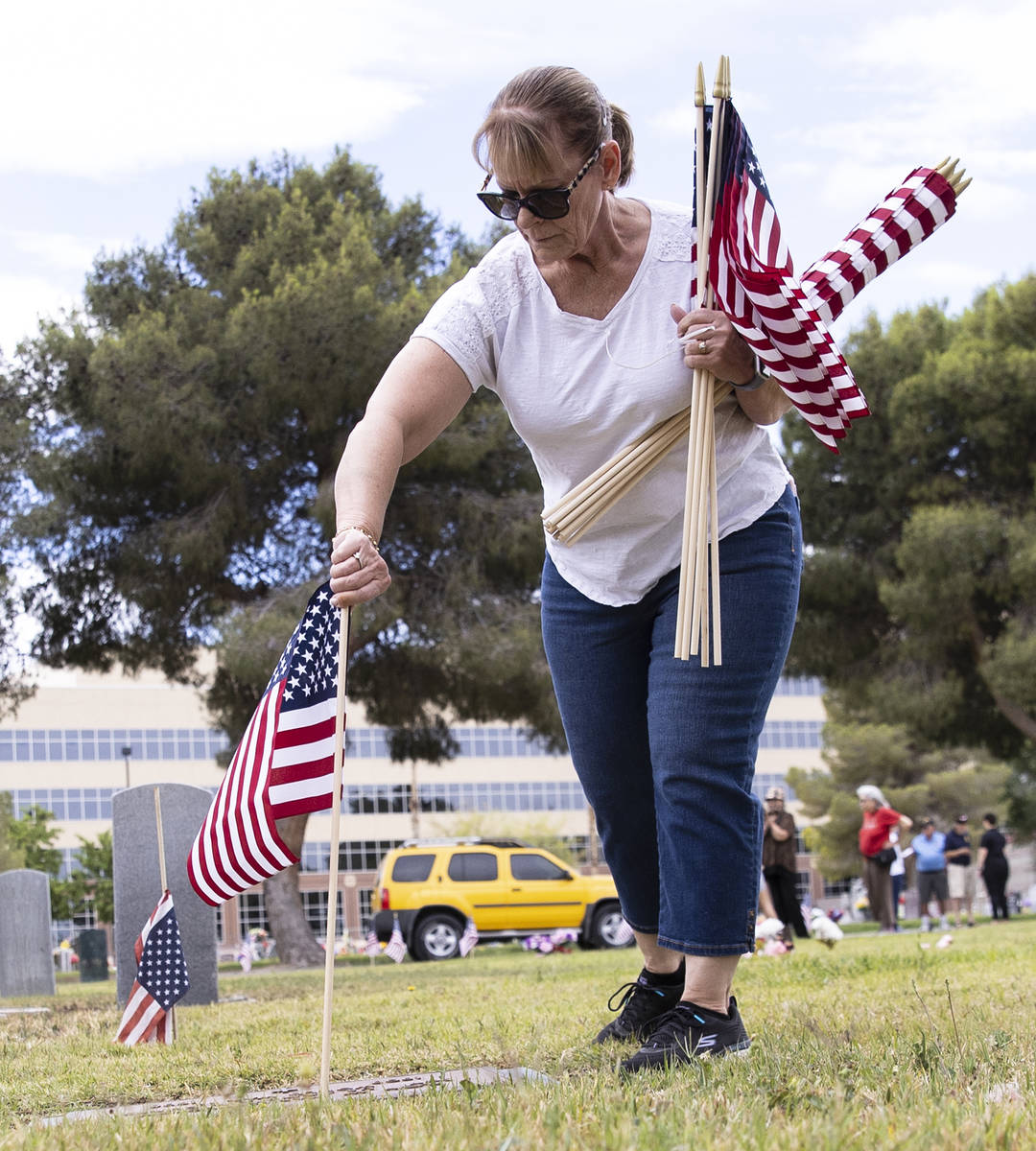 Lori Bordman coloca banderas estadounidenses en honor al Memorial Day, en las tumbas de los vet ...