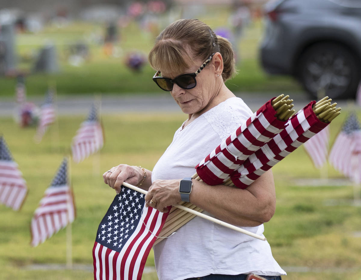 Lori Bordman coloca banderas estadounidenses en honor al Memorial Day, en las tumbas de los vet ...