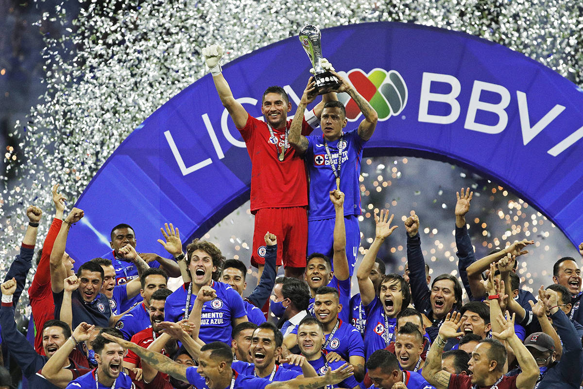 El portero de Cruz Azul, José Corona, a la izquierda, y Julio Domínguez levantan el trofeo lu ...