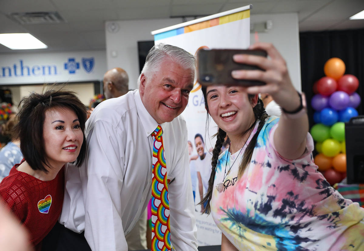 El gobernador Steve Sisolak, en el centro, se toma una selfie con Sydney Brandt, coordinadora d ...