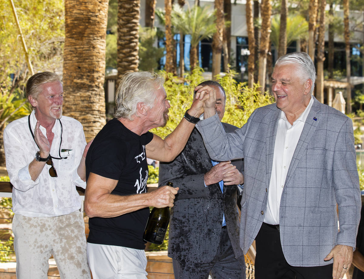 Sir Richard Branson, segundo por la izquierda, fundador de Virgin Group, choca los cinco con el ...