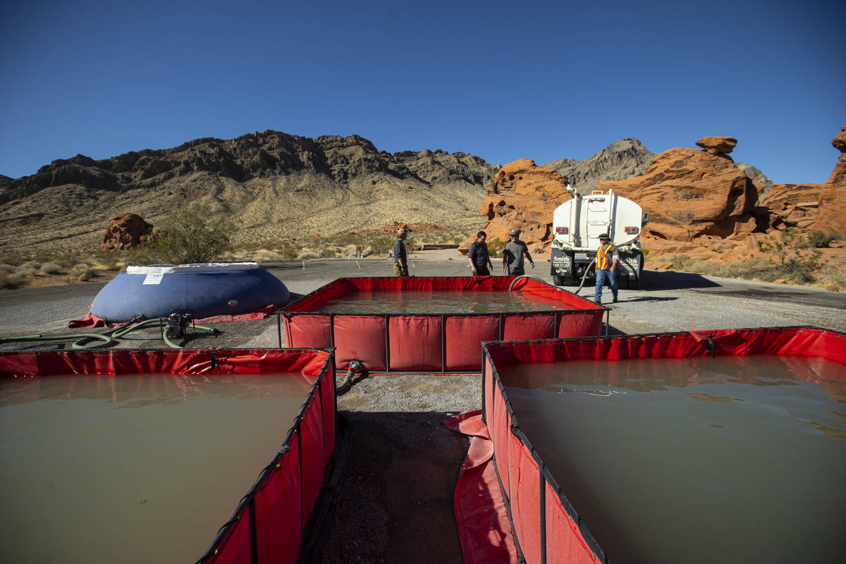 Water is prepared for transport by helicopter during an emergency water haul operation to reple ...