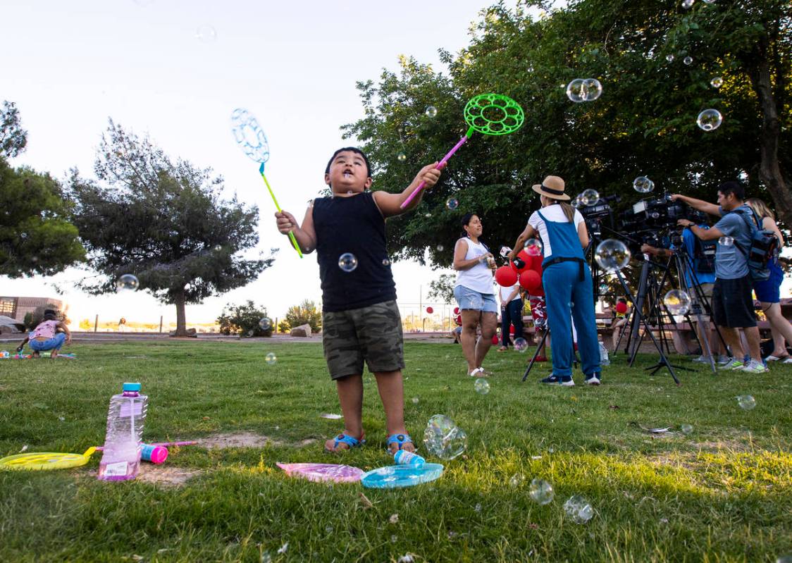 Aiden Trujillo Maldonado, de tres años, de Las Vegas, juega con burbujas durante una vigilia e ...