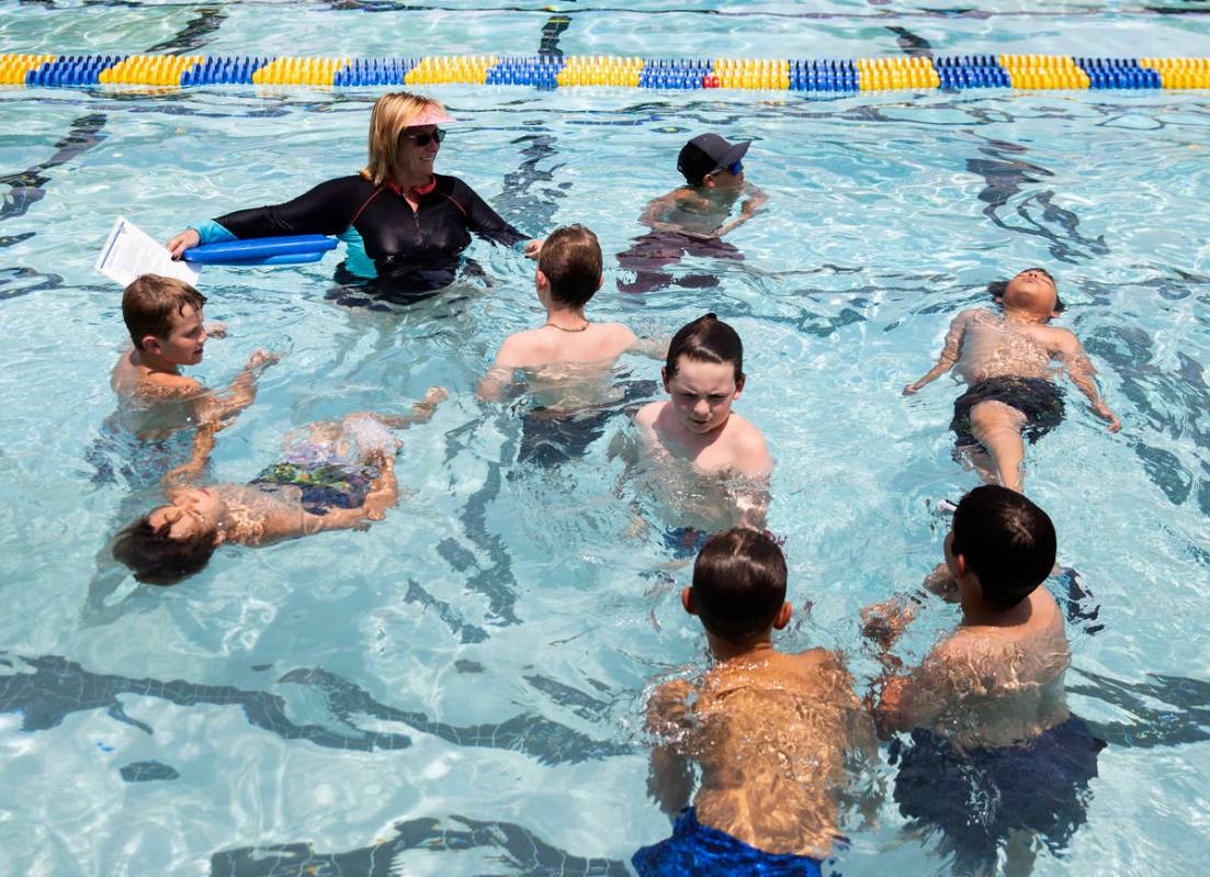 Kim Tyler, instructora voluntaria, observa cómo los niños nadan durante la 12ª Lección de n ...