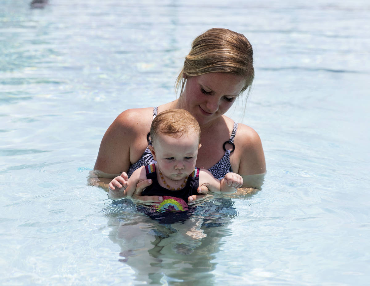 Taylor Speight da una lección de natación a su hija Stevie de siete meses en Boulder City Swi ...