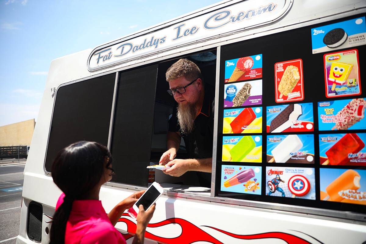 Al Davis, propietario de Fat Daddy's Ice Cream, entrega un helado a Jazmine Eady fuera de Calib ...