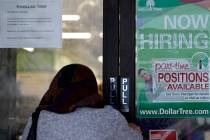 Una compradora entra en una tienda mientras un letrero de contratación se muestra en Buffalo G ...