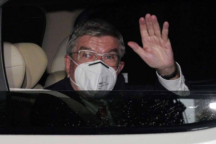 El presidente del Comité Olímpico Internacional, Thomas Bach, saluda desde el vehículo a los ...