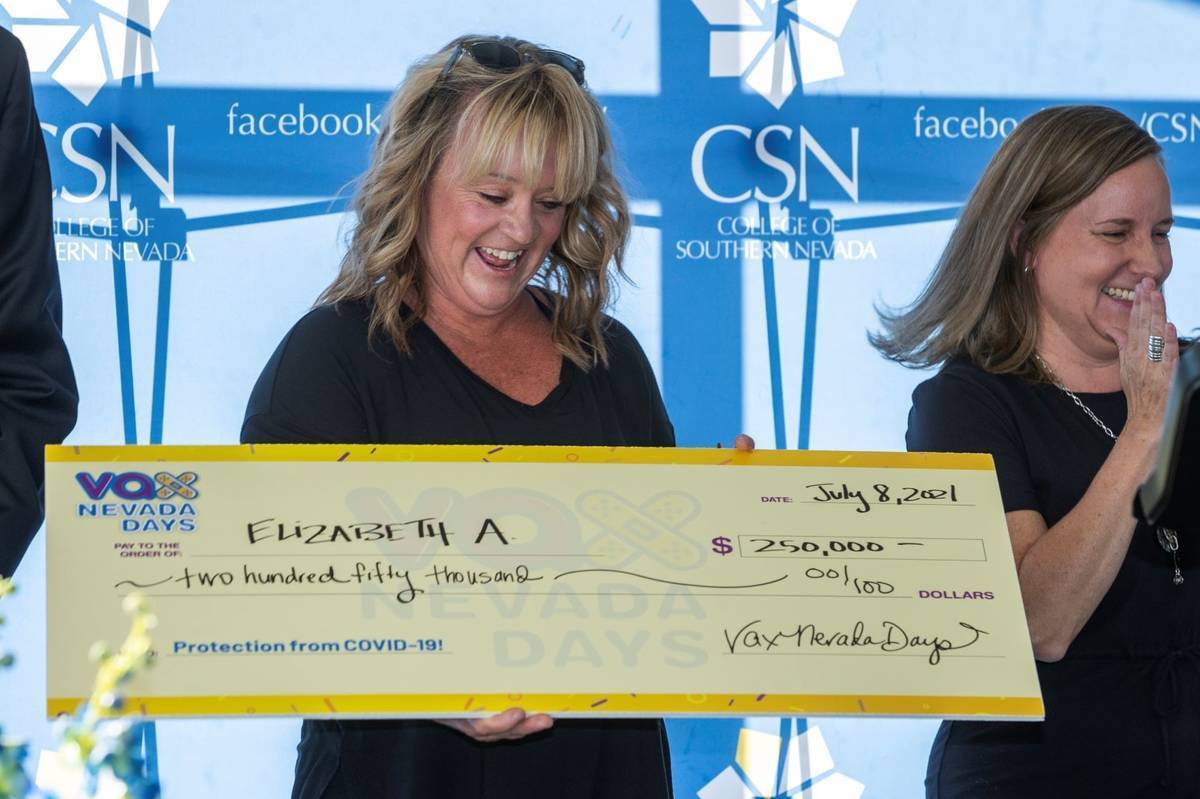 La maestra Elizabeth Allder mira su cheque de $250,000 mientras el gobernador Steve Sisolak e I ...