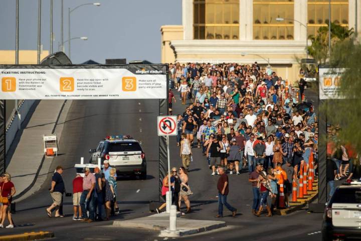 Fans caminan a través del paso elevado de Hacienda bajo el calor para el concierto de Garth Br ...