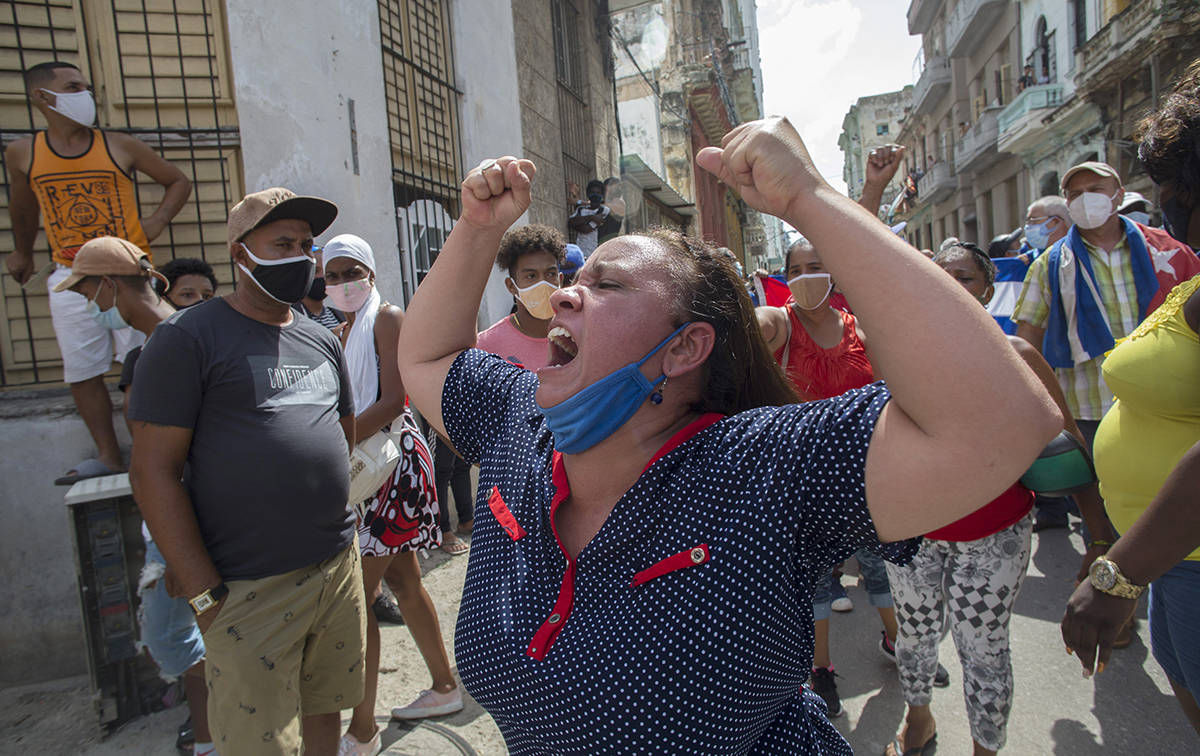 Una mujer grita consignas progubernamentales mientras manifestantes antigubernamentales marchan ...