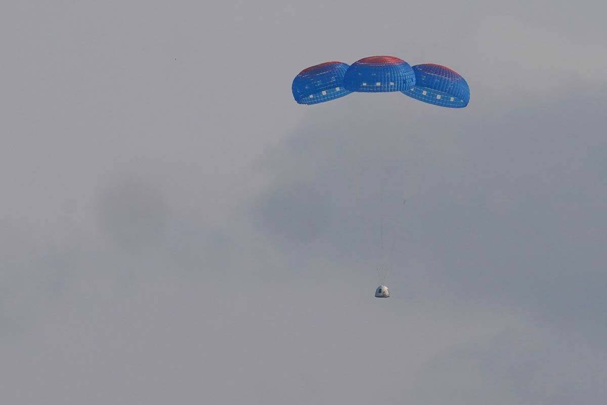 La cápsula New Shepard de Blue Origin desciende en paracaídas de forma segura hasta la zona d ...
