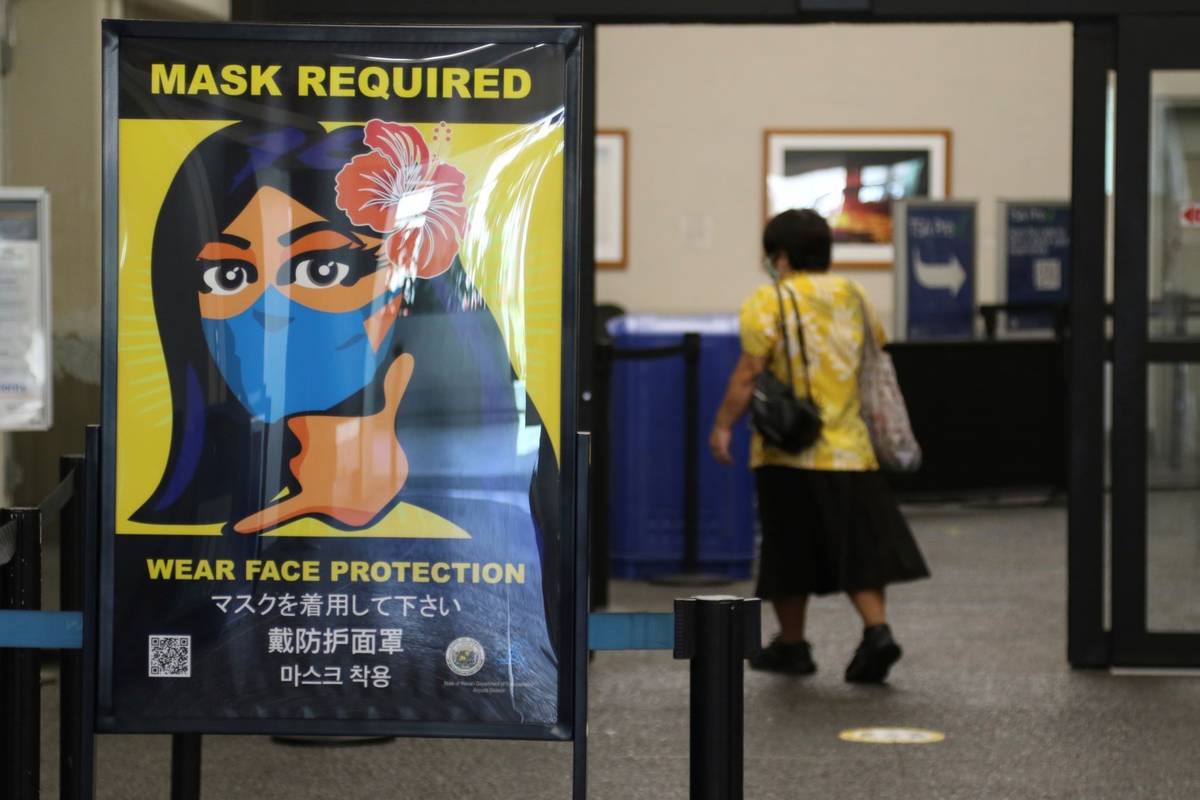 Una mujer entra en el aeropuerto internacional de Honolulu en octubre de 2020. (AP Photo/Caleb ...