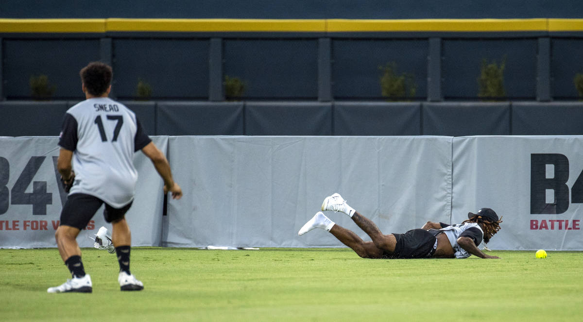 Damon Arnette (20, derecha) de los Raiders de Las Vegas, falla una fly ball larga mientras su c ...