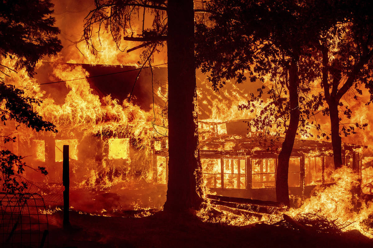 Las llamas del Dixie Fire consumen una casa en la comunidad de Indian Falls del Condado Plumas, ...