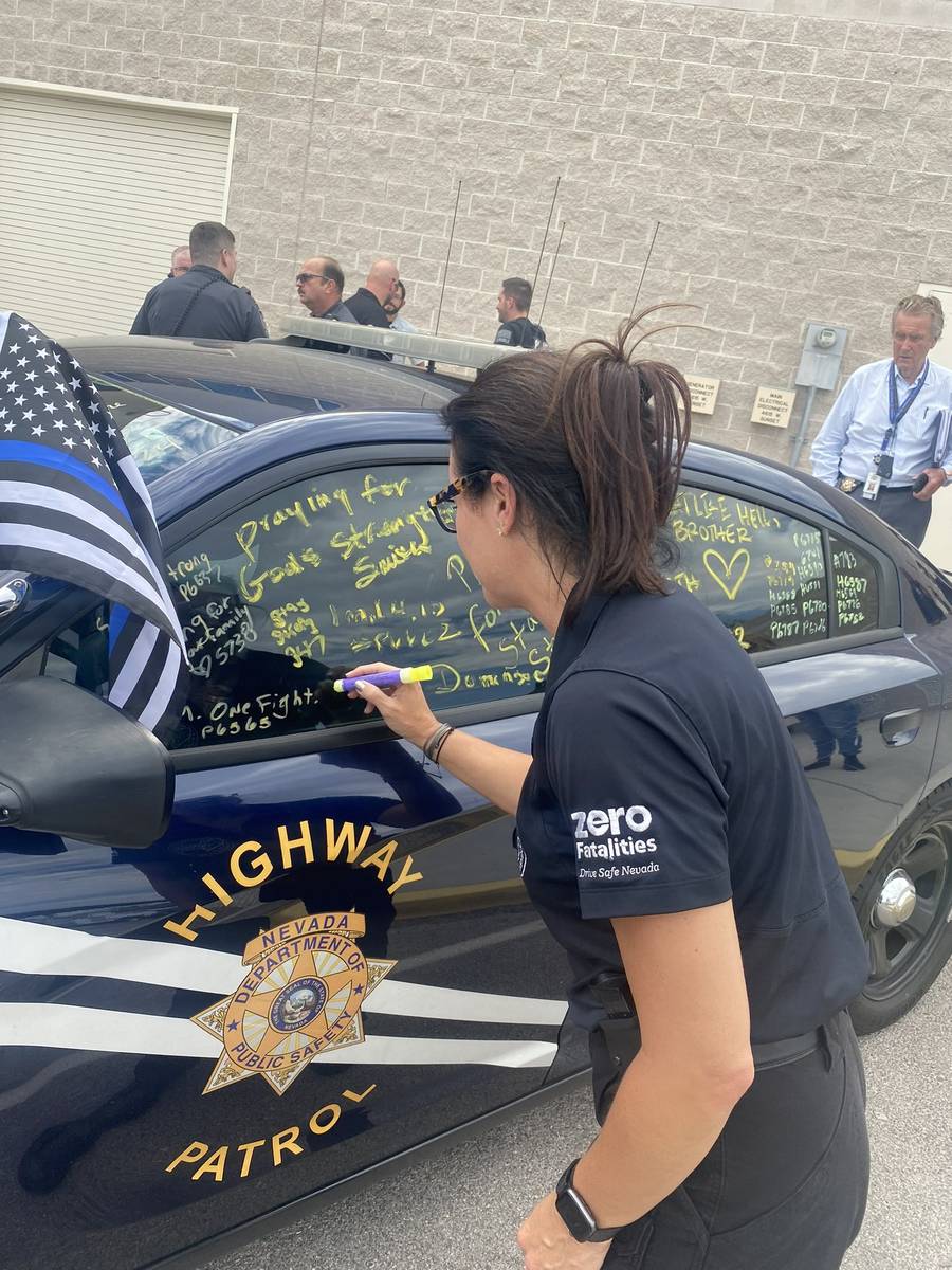 Miembros del Nevada Department of Public Safety firman el coche patrulla del soldado Micah May, ...