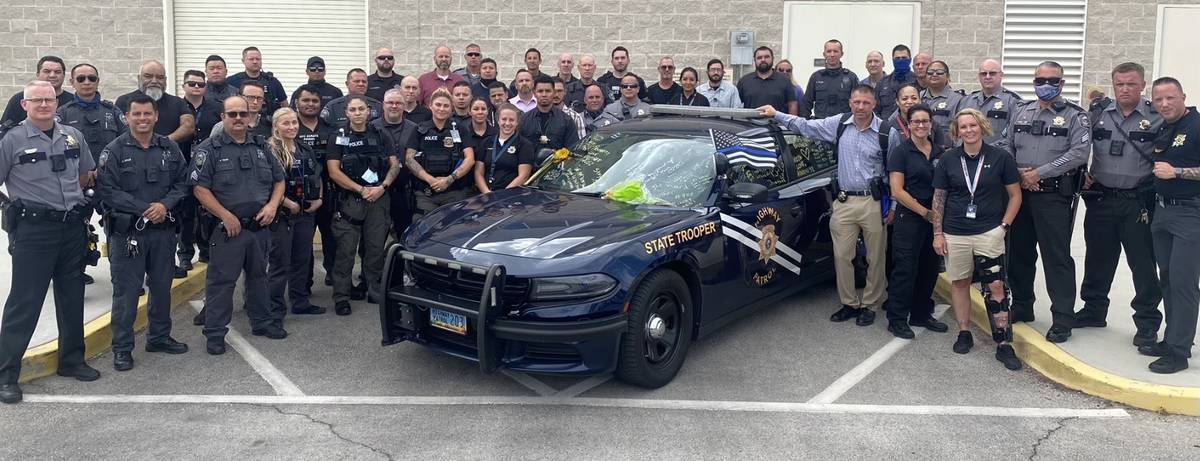 Miembros del Nevada Department of Public Safety firman el coche patrulla del soldado Micah May, ...