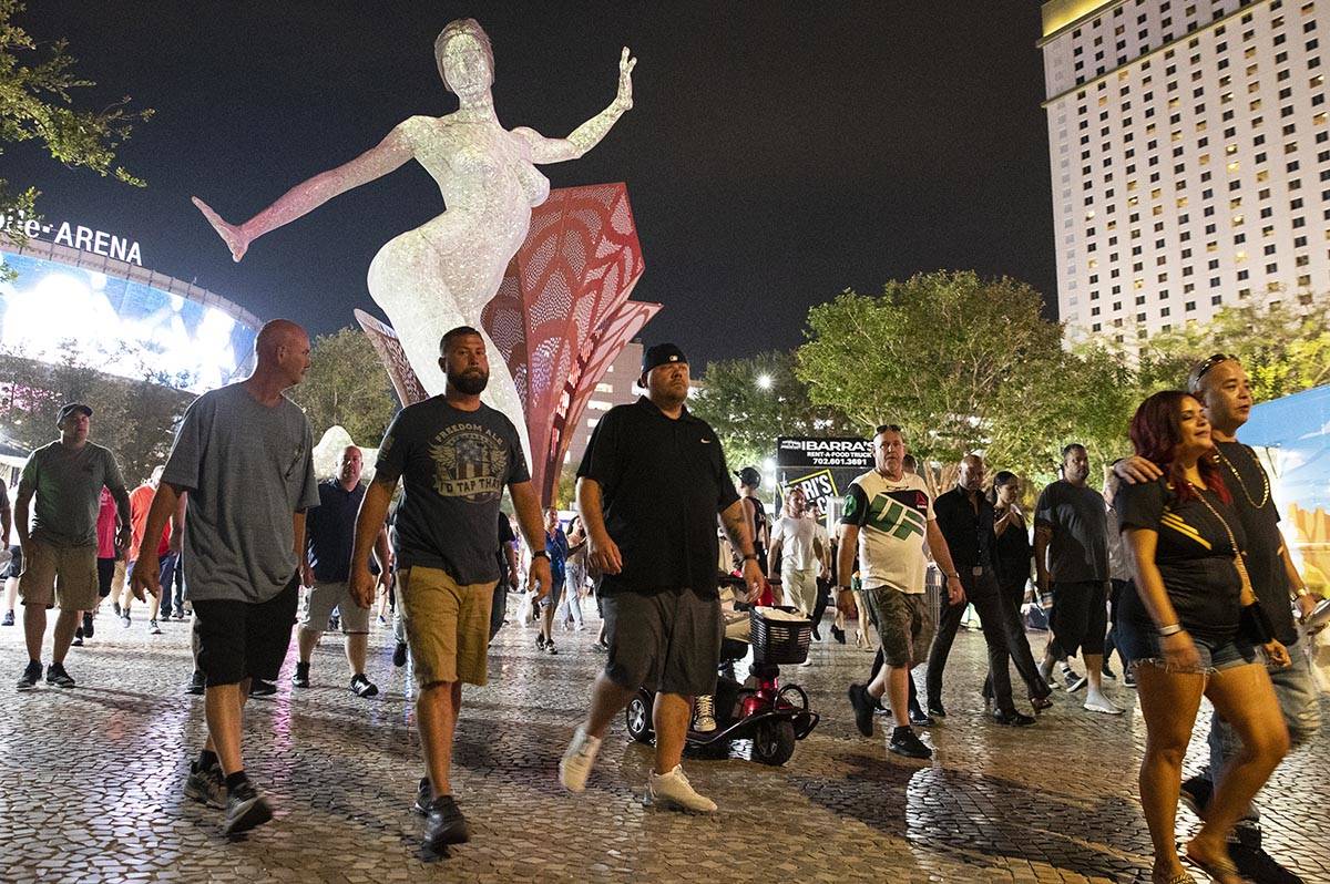 Gente, casi toda sin cubrebocas, caminan cerca de T-Mobile Arena, el sábado 10 de julio de 202 ...
