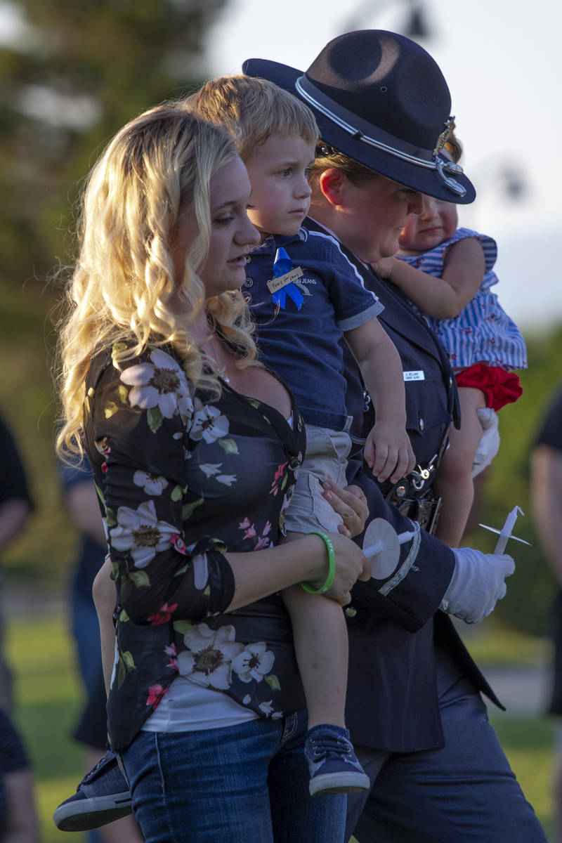Joanna May sostiene a su hijo Raylan May mientras un miembro de la Guardia de Honor lleva a su ...