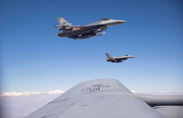 Dos F-16 vuelan junto a un KC-135 Stratotanker mientras éste reabastece de combustible a los a ...