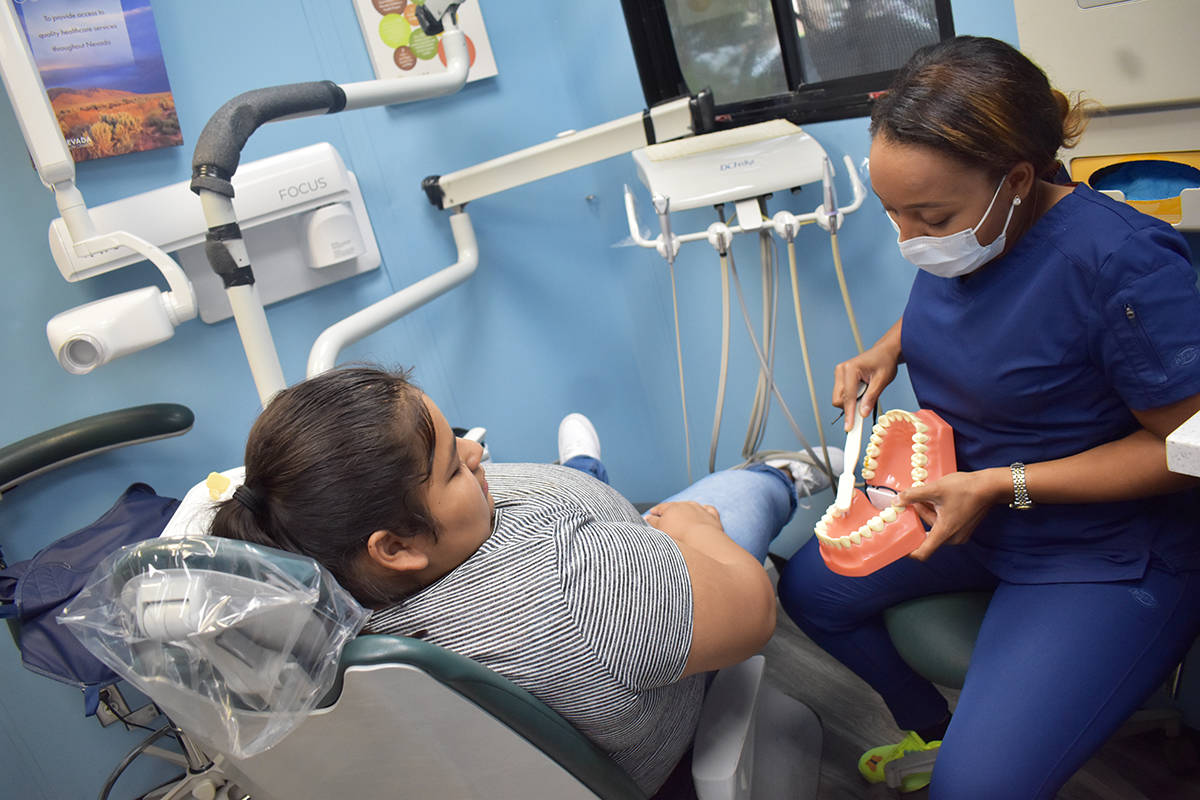 La dentista Alexandra Wabara le enseña a Jaqueline Silva cómo debe de cepillarse los dientes ...