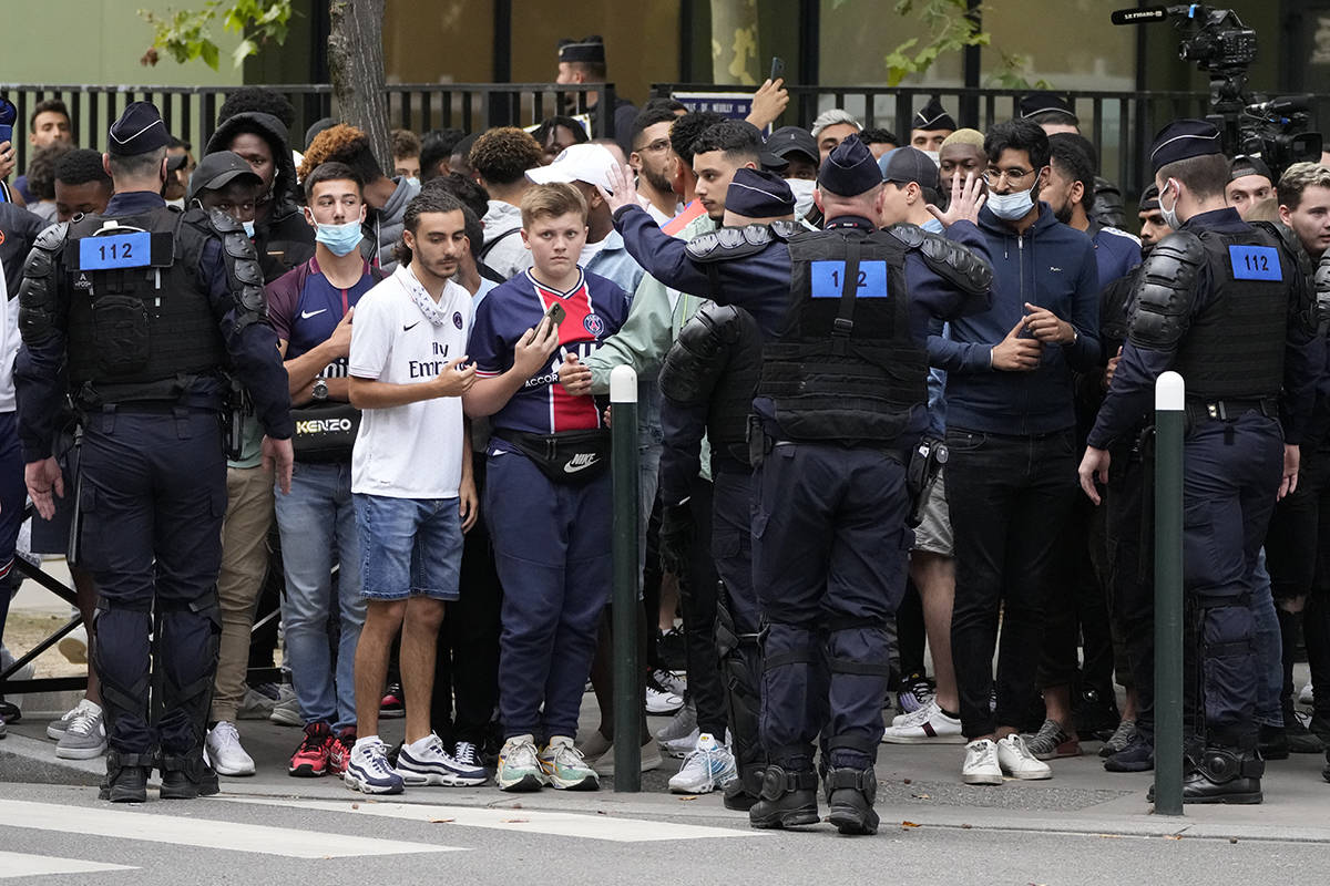 Agentes de la policía antidisturbios impiden que los aficionados del Paris Saint-Germain que s ...