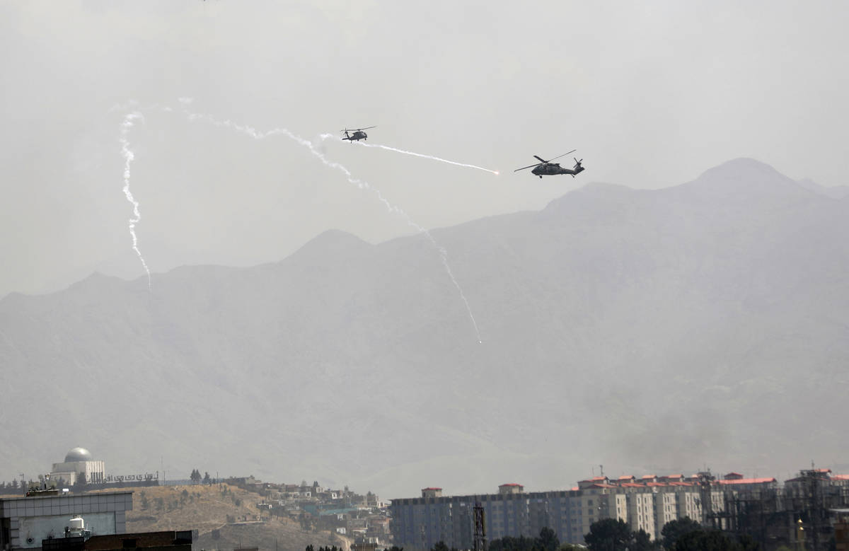 Se despliegan bengalas de señuelo antimisiles mientras helicópteros militares Black Hawk de E ...