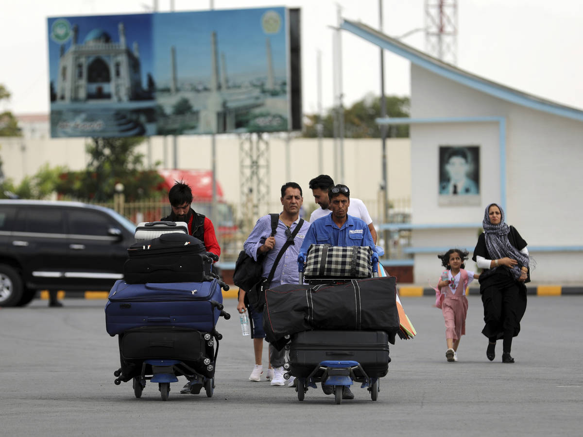 Pasajeros caminan hacia la terminal de salidas del Aeropuerto Internacional Hamid Karzai en Kab ...