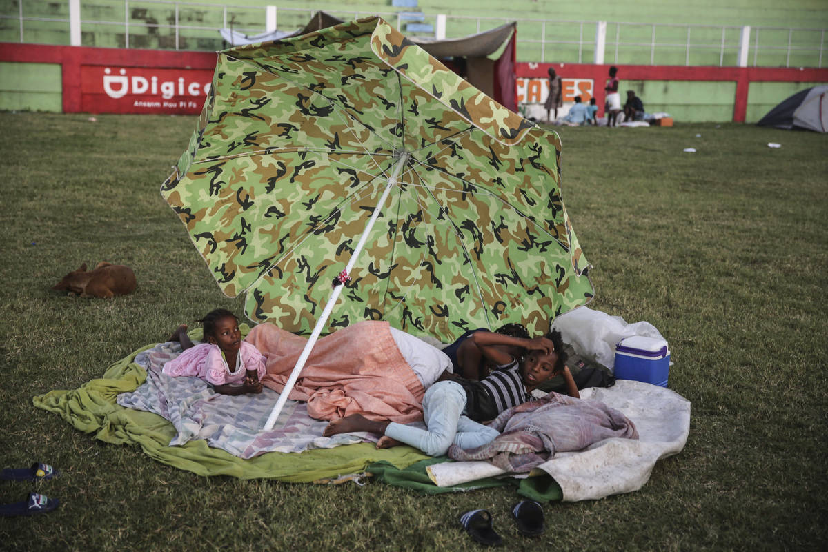 Gente descansa después de pasar la noche en un campo de fútbol tras el terremoto de magnitud ...