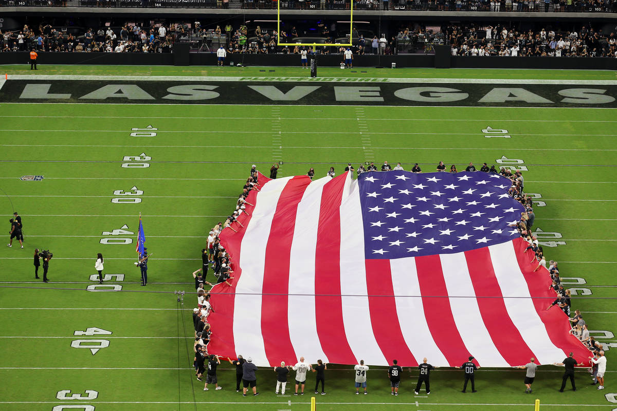 Una bandera de Estados Unidos se muestra en el campo durante el canto del himno nacional por Ma ...