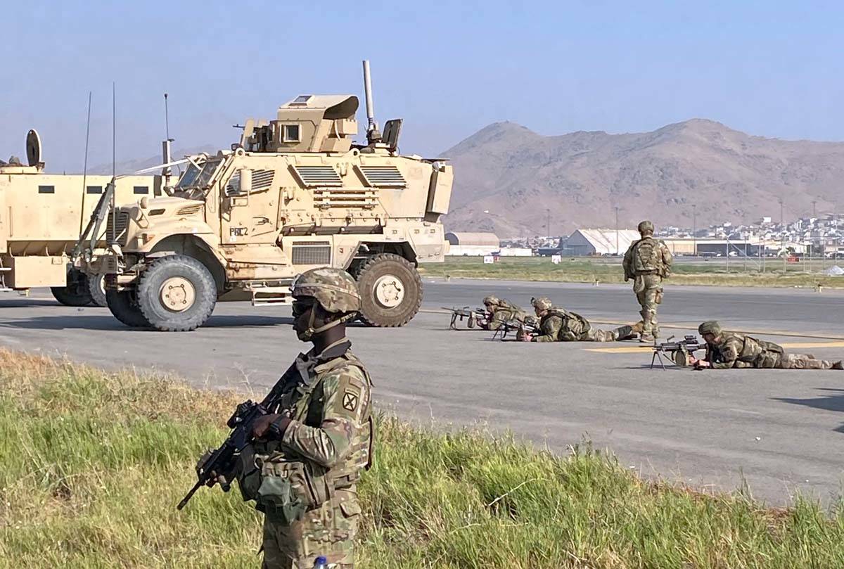 Soldados estadounidenses montan guardia a lo largo de un perímetro en el Aeropuerto Internacio ...