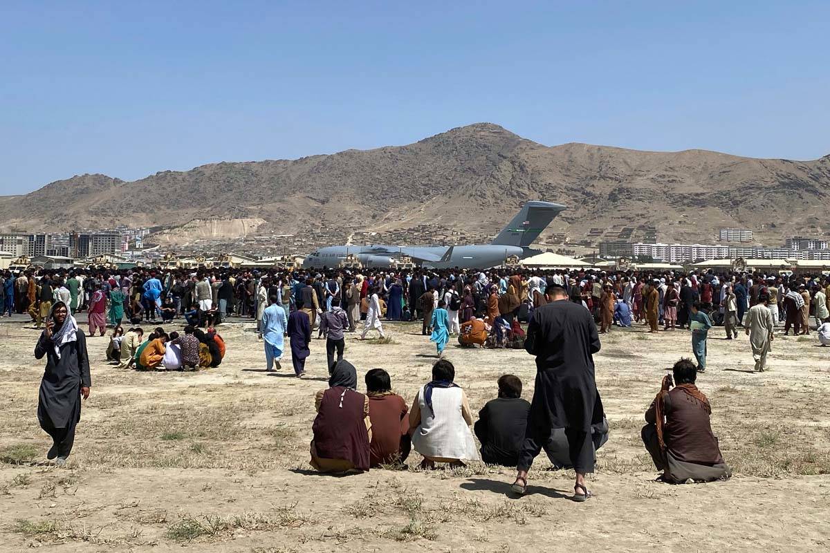 Cientos de personas se reúnen cerca de un avión C-17 de la Fuerza Aérea de Estados Unidos en ...