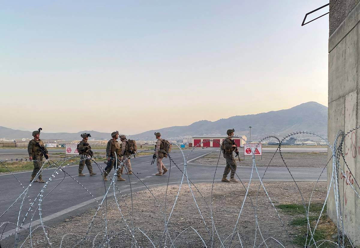 Soldados estadounidenses montan guardia a lo largo de un perímetro en el Aeropuerto Internacio ...