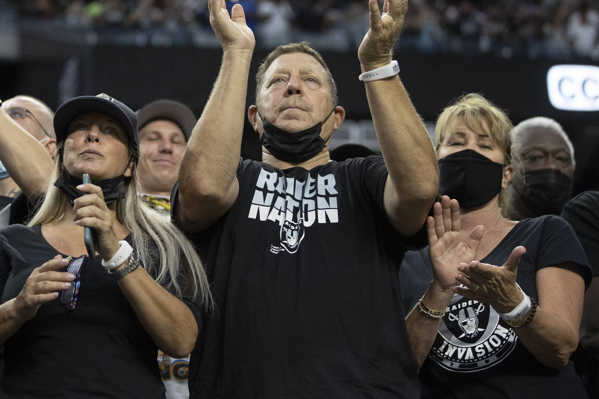 Los fans de los Raiders observan la acción durante un partido de fútbol americano de pretempo ...