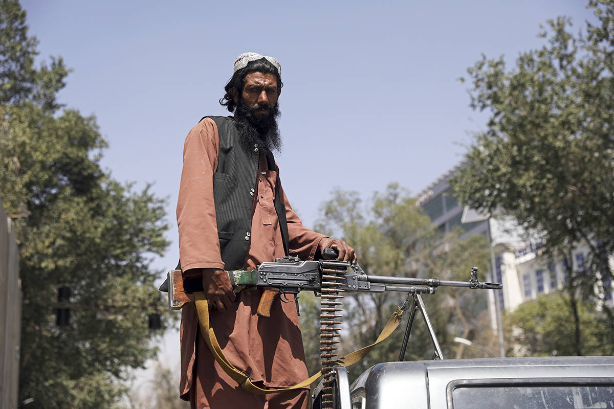Un combatiente talibán monta guardia en la puerta principal que conduce al palacio presidencia ...