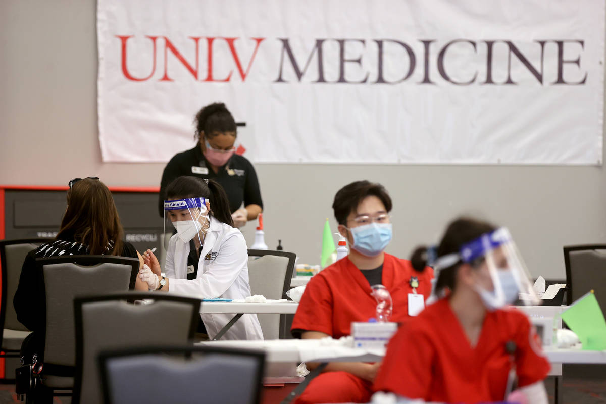 Angela Kong, a la izquierda, una estudiante de enfermería del Nevada State College, aplica una ...