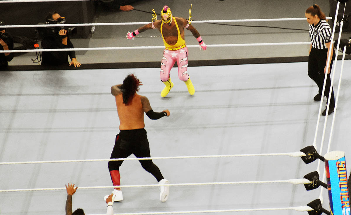Rey Mysterio, vestido de rosa con amarillo, peleando contra Jimmy Usos. El sábado 21 de agosto ...