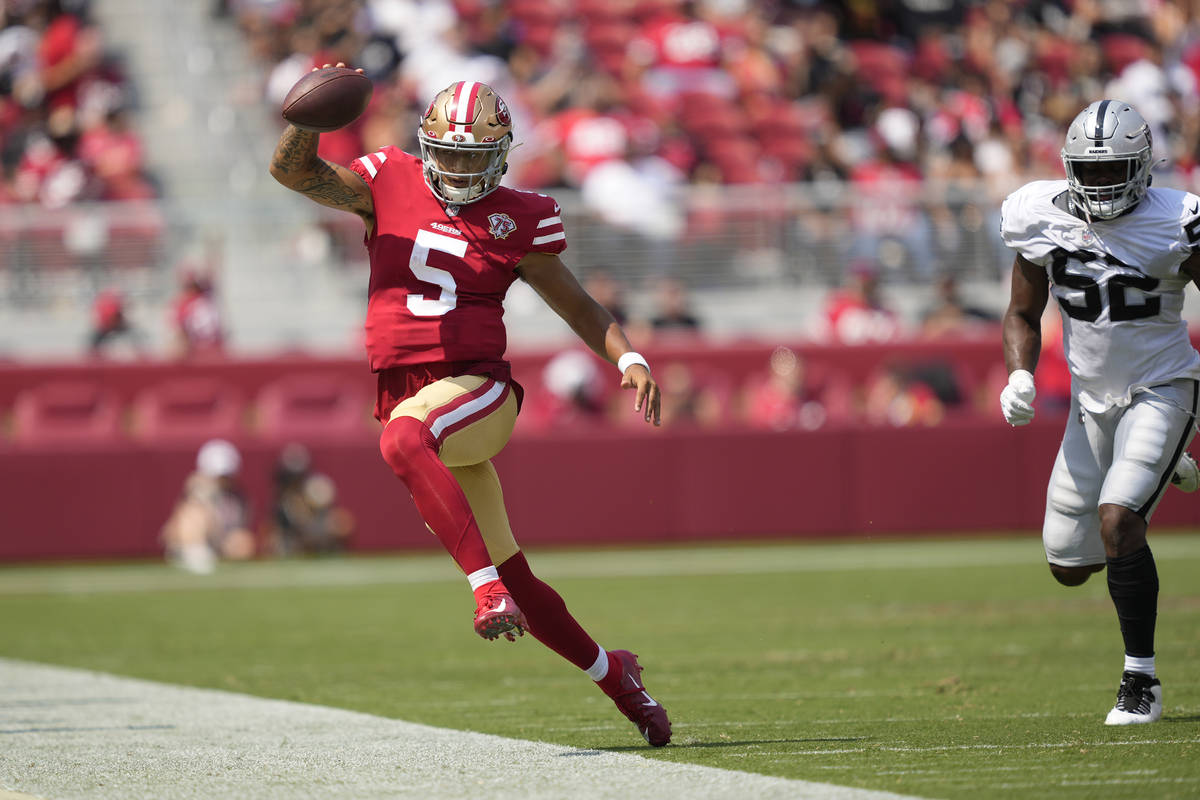 El quarterback de los San Francisco 49ers, Trey Lance (5), corre fuera de los límites contra l ...