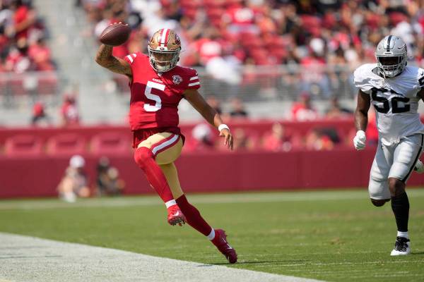 El quarterback de los San Francisco 49ers, Trey Lance (5), corre fuera de los límites contra l ...