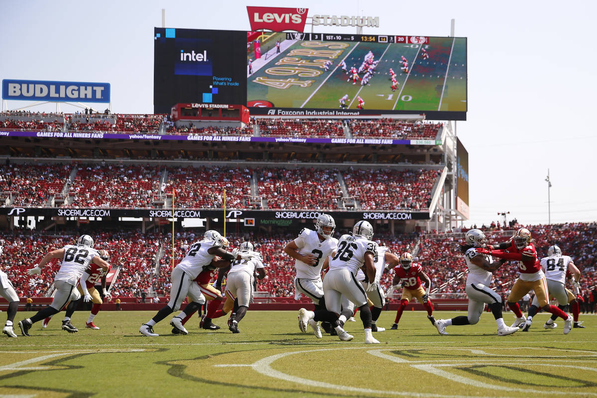 El quarterback de los Raiders de Las Vegas, Nathan Peterman (3), entrega el balón al running b ...
