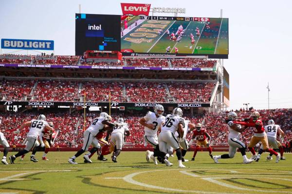 El quarterback de los Raiders de Las Vegas, Nathan Peterman (3), entrega el balón al running b ...