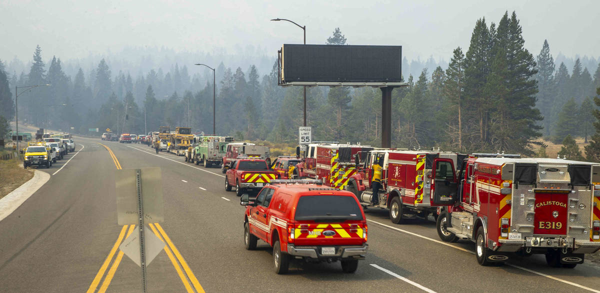 Docenas de vehículos de emergencia se ponen en escena mientras el humo llena el cielo en la in ...